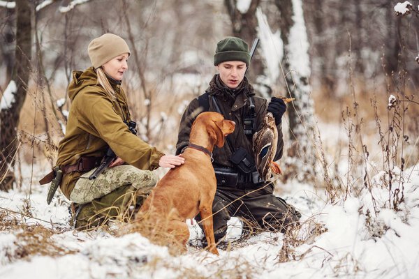 два охотника с винтовками в снежном зимнем лесу
. 