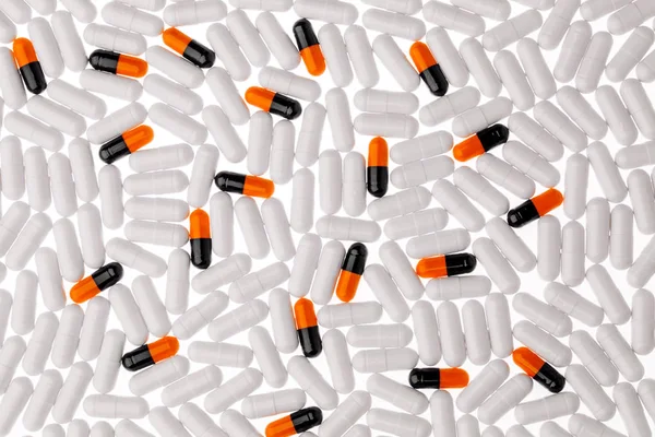 Cápsulas de pastillas negras, naranjas y blancas. Medicina y farmacia co —  Fotos de Stock