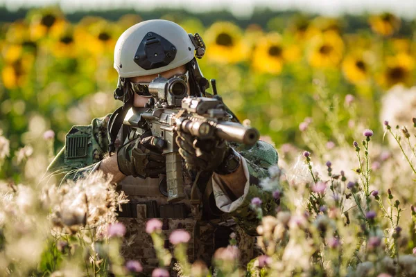 Portrait of young soldier  with rifle against a sunset backgroun — Stock Photo, Image