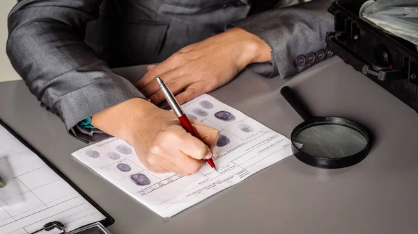 Detective experto escribe datos en la tabla de huellas dactilares — Foto de Stock