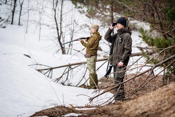 Man och kvinna jägare redo för att jaga, hålla pistolen och gå i — Stockfoto