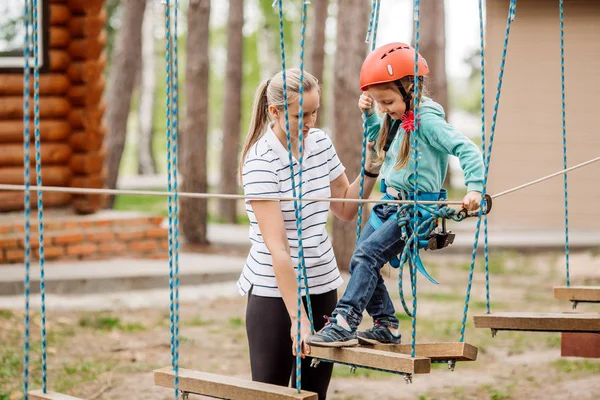 Ausbilder hilft dem Kind auf der Seilbahn in der Trainingskamera — Stockfoto