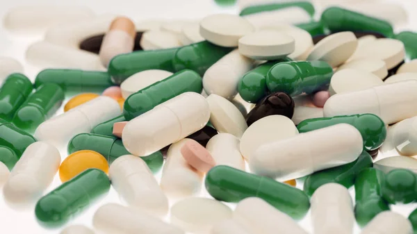 Primer plano de cápsulas de píldoras aleatorias. Concepto de medicina y farmacia —  Fotos de Stock