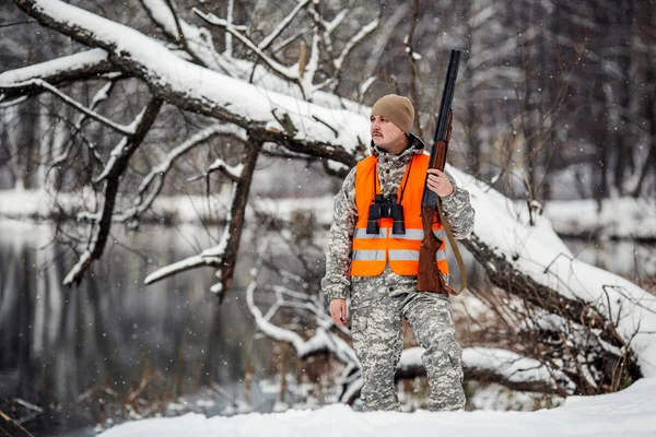 Homme chasseur en camouflage, armé d'un fusil, debout dans une sno — Photo