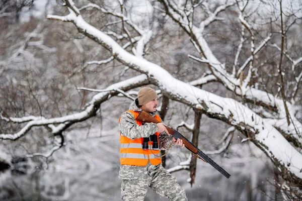 Male hunter in camouflage, armed with a rifle, standing in a sno — Stock Photo, Image
