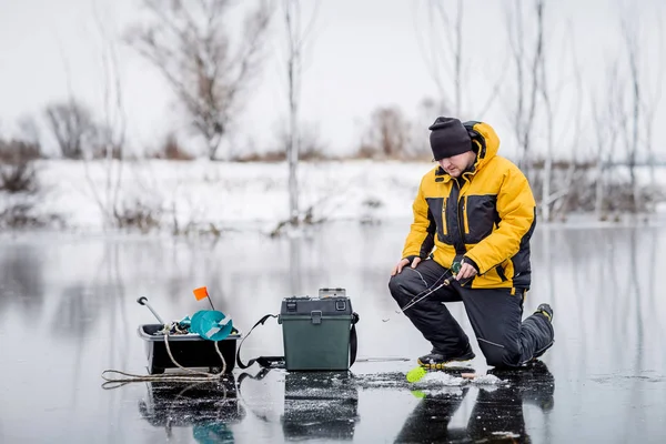 Man ice fishing on a frozen lake. — Stock Photo, Image