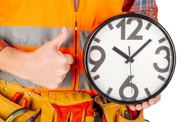 Männlicher Baumeister mit großer Uhr über weißem Wandhintergrund. — Stockfoto