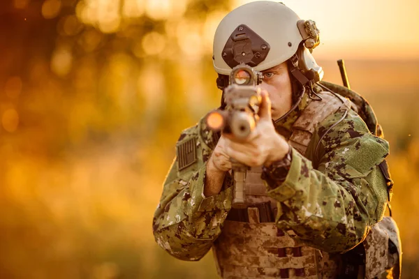 Portrait de jeune soldat visage avec camouflage contre un coucher de soleil — Photo