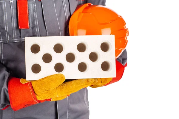 Bauarbeiter mit Ziegel und Helm in der Hand — Stockfoto