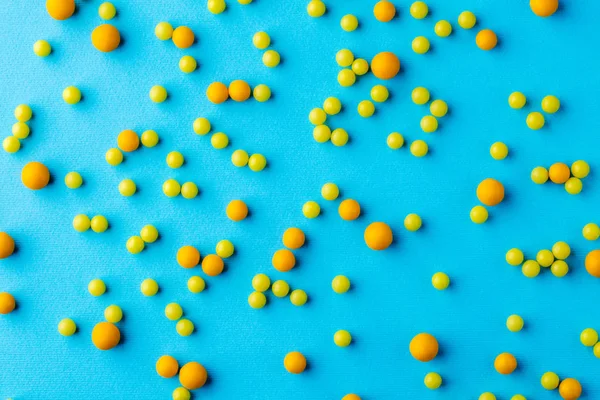 Many yellow pills on blue background — Stock Photo, Image