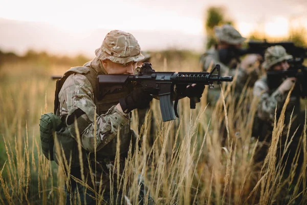 Rangers tirant avec son arme, fusil au coucher du soleil. Guerre, armée, mi — Photo