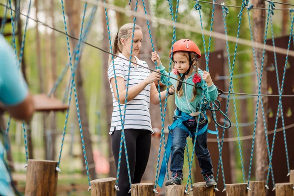 Ausbilder hilft dem Kind auf der Seilbahn in der Trainingskamera — Stockfoto