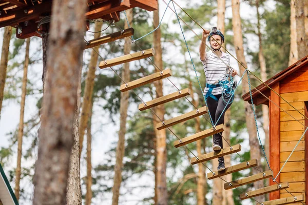 Girl with climbing gear  in an adventure park are engaged in roc — Stock Photo, Image