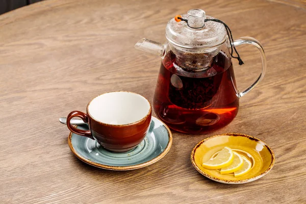 お茶の中に木製テーブルの上にガラスのティーポット — ストック写真