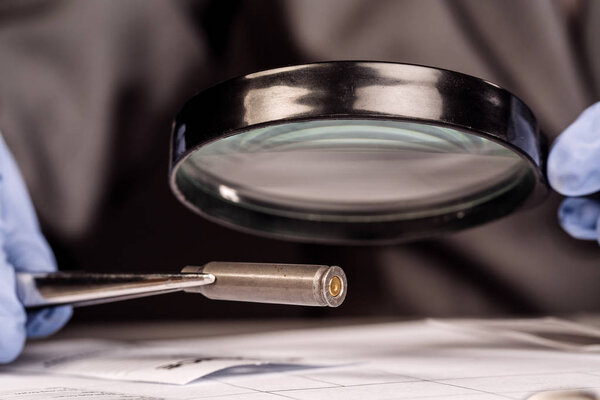 Detective through a magnifying glass looking at a evidence