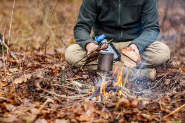 Elleri kırma ve ekmek kızartma bir avcı. Bushcraft kavramı