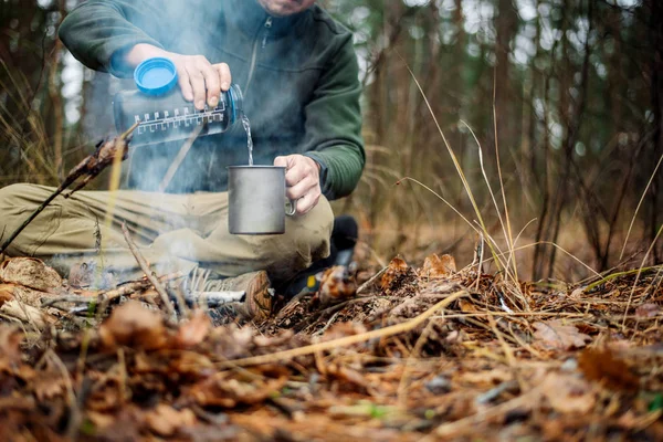 avcı metal bir kupa bir şişe su dökülen. Bushcraft, reklam