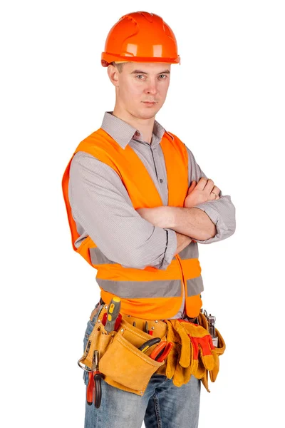 Constructor masculino en un casco con brazos cruzados y mirando a la cámara sobre fondo blanco de la pared. reparación, construcción, construcción, personas y concepto de mantenimiento . — Foto de Stock