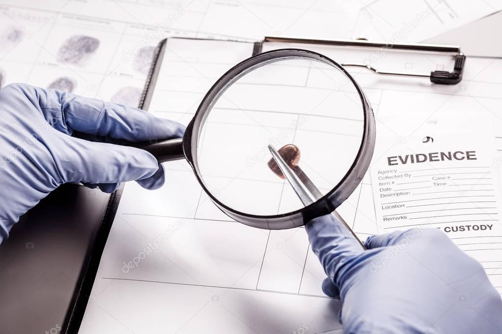 Detective through a magnifying glass looking at a evidence