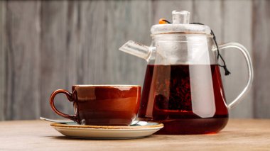 ahşap masa üzerinde içinde biraz çay ile cam çaydanlık