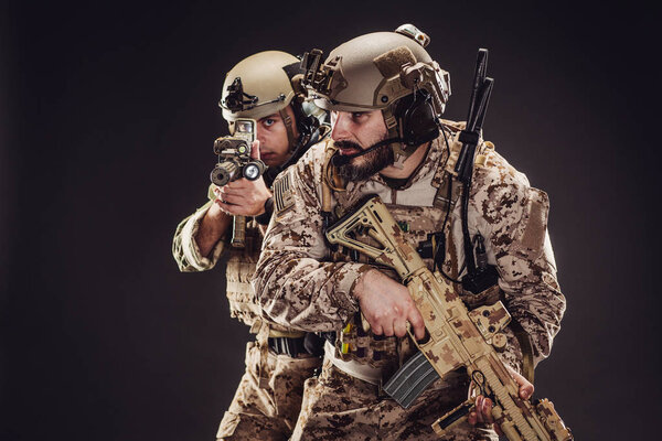 Special forces United States soldiers or private military contractors holding rifle. Image on a black background. war, army, weapon, technology and people concept