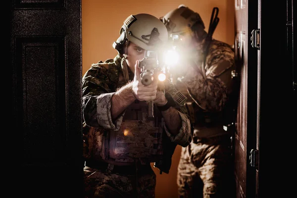 Tentara atau kontraktor militer swasta memegang senapan. Gambar dinyalakan — Stok Foto