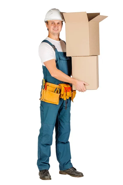Manliga builder eller arbetare i hjälmen håller hög av kartonger över vit vägg bakgrund. reparation, konstruktion, byggnad, människor och underhåll begrepp — Stockfoto
