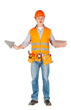 Oluşturucusu'nda bir kask bir tuğla ve mala tutarak ve beyaz duvar arka plan üzerinde kameraya bakıyor. onarım, inşaat, yapı, insanlar ve bakım kavramı.