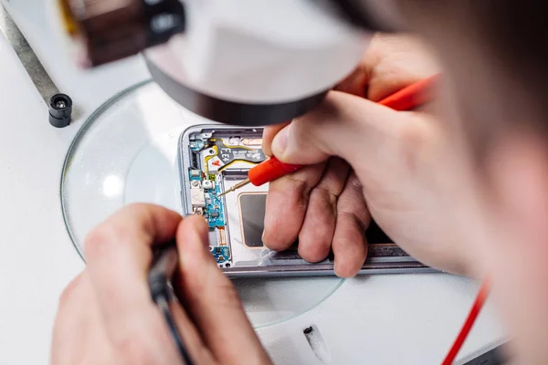 Крупним планом руки працівника сервісу ремонту сучасних смартфонів . — стокове фото