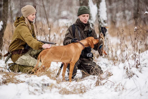 Due cacciatori con fucili in una foresta invernale innevata . — Foto Stock