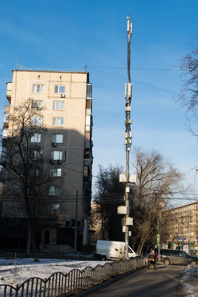 Antena celular na rua na cidade entre as casas — Fotografia de Stock
