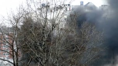 Şehir, siyah duman içinde ateş