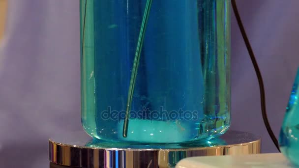 Glödlampa med roterande blå vätska — Stockvideo