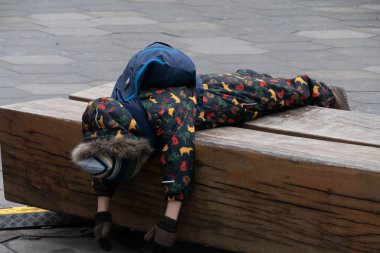 Çocuk giysiler içinde yatıyor.