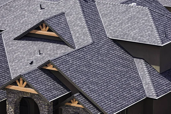 Rooftop in a newly constructed subdivision in Kelowna British Columbia Canada showing asphalt shingles — Stock Photo, Image