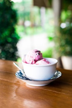 Tahta bir masada, fincanda dondurma.