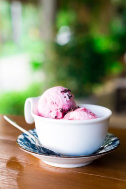 Tahta bir masada, fincanda dondurma.