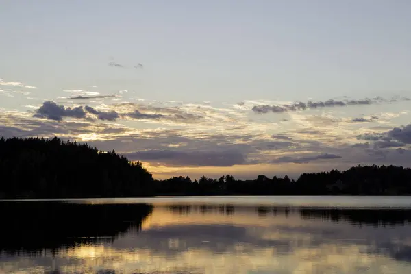 Solnedgång över sjön med skog och moln — Stockfoto