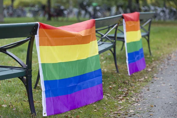 Banderas de arco iris colgadas en bancos — Foto de Stock