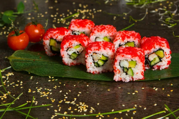 Various kind of sushi food served on black background. Close up of tasty fresh sushi rolls with fish and rice on plate. Sushi rolls served on a wooden plate in a restaurant