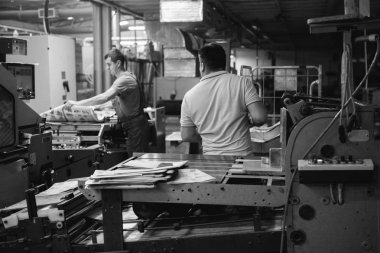 Kişinev, Moldova - 26 Nisan 2016: İşçilerin basımevi. Yazdırma fabrikasında baskı makinesinde çalışan insanlar. Kişinev, Moldova üzerinde 26 Nisan 2016 yılında sanayi işçileri