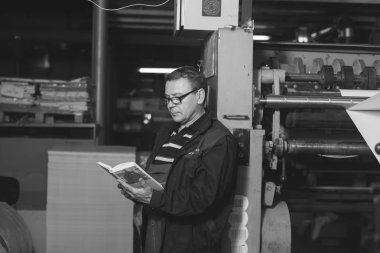 Kişinev, Moldova - 26 Nisan 2016: İşçilerin basımevi. Yazdırma fabrikasında baskı makinesinde çalışan insanlar. Kişinev, Moldova üzerinde 26 Nisan 2016 yılında sanayi işçileri