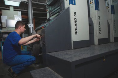 Kişinev, Moldova - 26 Nisan 2016: İşçilerin basımevi. Yazdırma fabrikasında baskı makinesinde çalışan insanlar. Kişinev, Moldova üzerinde 26 Nisan 2016 yılında sanayi işçileri