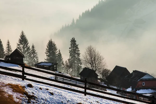 Wunderschöne Winterlandschaft in den Bergen. Sonnenaufgang. karpatisches Tal mit Nebel und Schnee. Karpaten-Winterberge. frühmorgendliches Licht lag auf einem Berghügel. — Stockfoto