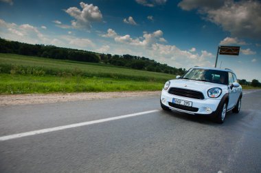 Kişinev, Moldova. 14 Temmuz 2016: Mini Cooper Kulübü Festivali Moldova. Turuncu Mini Cooper karanlık orman üzerinde 14 Temmuz 2016 yılında Kişinev, Moldova.