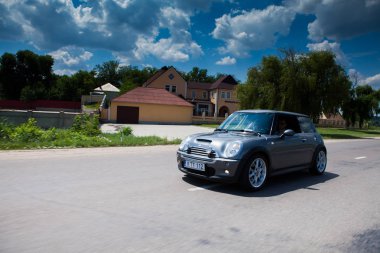 Kişinev, Moldova. 14 Temmuz 2016: Mini Cooper Kulübü Festivali Moldova. Turuncu Mini Cooper karanlık orman üzerinde 14 Temmuz 2016 yılında Kişinev, Moldova.