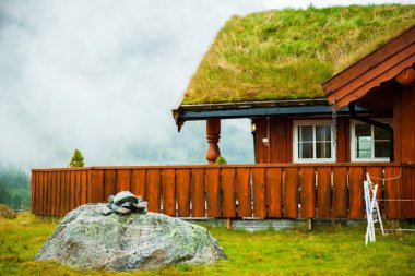Geleneksel Norveç ahşap ev ayakta bir çim ve dağlar içinde belgili tanımlık geçmiş. Tipik Norveç ev. çatı çimen ile tipik Norveç ev.