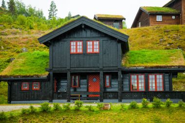 Geleneksel Norveç ahşap ev ayakta bir çim ve dağlar içinde belgili tanımlık geçmiş. Tipik Norveç ev. çatı çimen ile tipik Norveç ev.