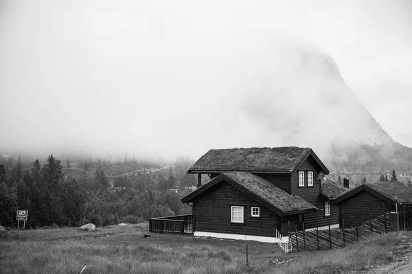 Geleneksel Norveç ahşap ev ayakta bir çim ve dağlar içinde belgili tanımlık geçmiş. Tipik Norveç ev. çatı çimen ile tipik Norveç ev. — Stok fotoğraf