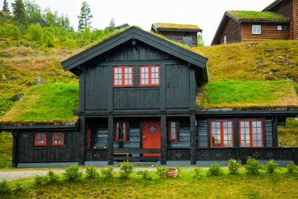 Geleneksel Norveç ahşap ev ayakta bir çim ve dağlar içinde belgili tanımlık geçmiş. Tipik Norveç ev. çatı çimen ile tipik Norveç ev.